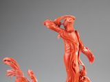 a statue of a woman holding a bird on a branch