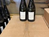 three bottles of wine sitting on top of a box on a table