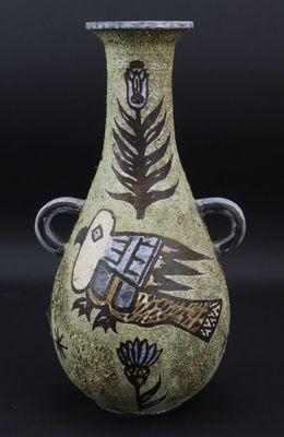 un vase vert orné d'un motif sur fond noir