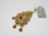 a close up of a gold necklace with a blue stone on it