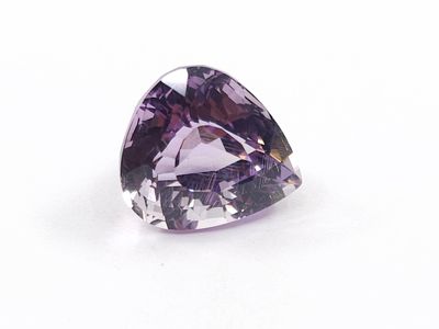 a close up of a purple diamond on a white surface