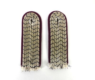 deux paires de poignets brodés, ornés de franges et de pompons