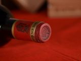 a bottle of wine sitting on a red table cloth