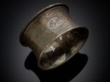 une vieille bague en argent ornée d'un motif sur un fond noir