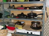 de nombreuses casseroles et poêles sur les étagères de la cuisine