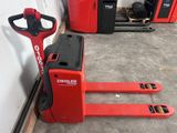 un chariot élévateur rouge garé dans un garage, près d'un mur