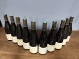 six bottles of wine lined up in a row on a wooden table