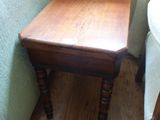 une petite table et une chaise en bois dans un coin de la pièce
