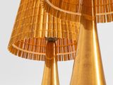two golden lamps that are sitting on a table