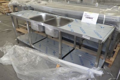 Plusieurs éviers en acier inoxydable sont exposés dans un entrepôt