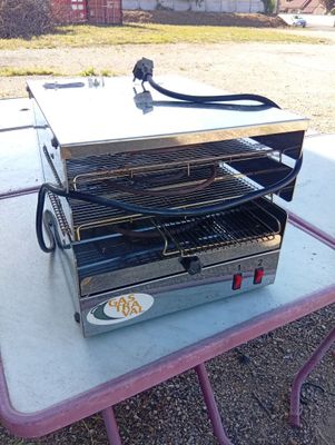a small table with a grill on it in the yard