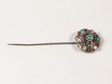 a close up of a brooch on a white surface