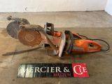 a chainsaw that is laying on the ground next to a sign