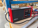 un chargeur de batterie rouge et noir posé sur une table