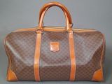 an image of a brown and tan duffel bag on a gray background
