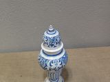 a blue and white vase with a lid on a table