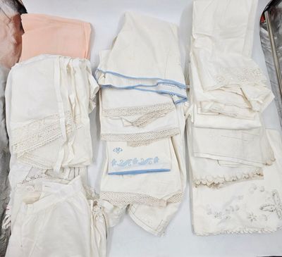 une valise pleine de vêtements et des vêtements posés sur une table