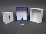 a small figurine of a man standing in a box