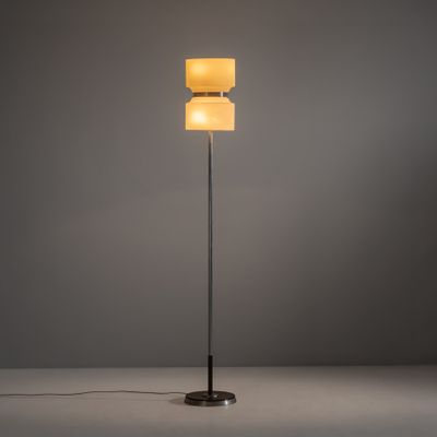 Le lampadaire est doté d'un abat-jour en verre et d'un pied en métal