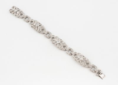 a close up of a diamond bracelet on a white surface