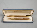 a gold plated pen in a blue box with a gold trim