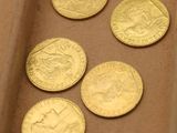 plusieurs pièces d'or posées sur une boîte en carton