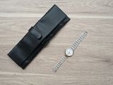 a watch and a watch case on a wooden floor