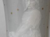 a white vase with a statue of a woman in it