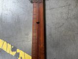 un vieil instrument en bois posé par terre, à côté d'une ligne jaune