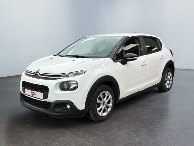 Une Citroën blanche est garée dans une pièce blanche