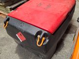 a suitcase that is sitting on the ground next to a pile of wood