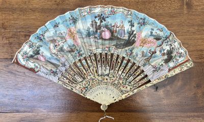 a fan on a wooden table with a key in it