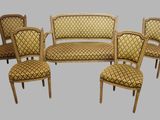 four chairs and a couch in a room with a gray background