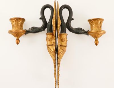 a wall sconce with two candle holders attached to it