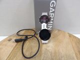 a garmin watch sitting on a wooden table next to a box