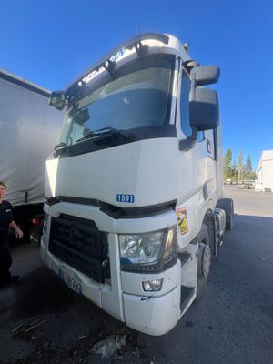 un homme debout à côté d'un gros camion sur un parking