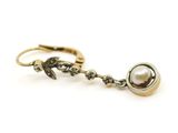 une photo d'une paire de boucles d'oreilles en or ornées de perles