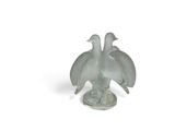 a glass figurine of two birds sitting on a plate