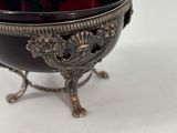 an antique silver and black bowl on a stand on a white surface