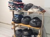 many bags of clothes on a shelf in a room
