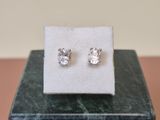 a pair of earrings sitting on top of a marble block