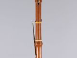 an old wooden flute with a black and white stripe on it