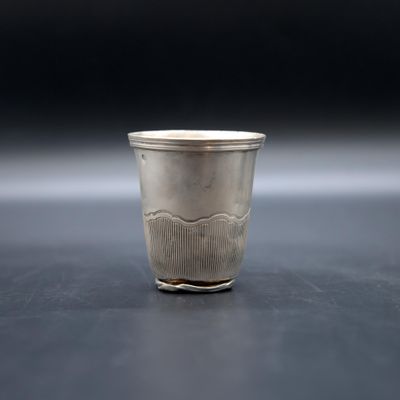a silver cup sitting on a table with a black background