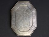 an antique silver plate with a picture of a man on a horse