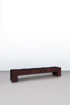 un banc en bois posé sur un sol blanc, près d'un mur