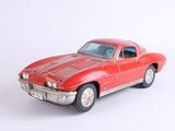 une petite voiture rouge posée sur une surface blanche
