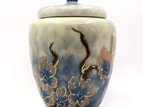 a blue and white vase with a flower design on it