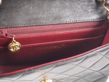 a black and red purse with a gold handle