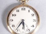 a close up of a pocket watch on a white surface