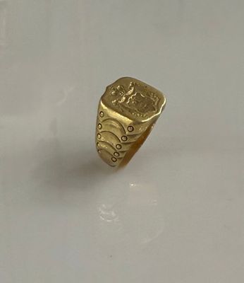 une bague en or sur laquelle est gravée l'image d'un homme et d'une femme